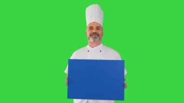 Gülümseyen erkek aşçı yeşil ekranda boş bir tahta tutuyor, Chroma Key..