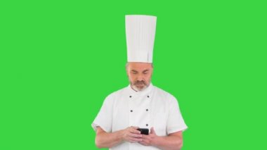 Baş aşçı yürüyor ve yeşil ekranda cep telefonu kullanıyor, Chroma Key.