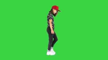 Yeşil ekranda yürüyen ve ayaklarına bakan tatlı Asyalı kız, Chroma Key..