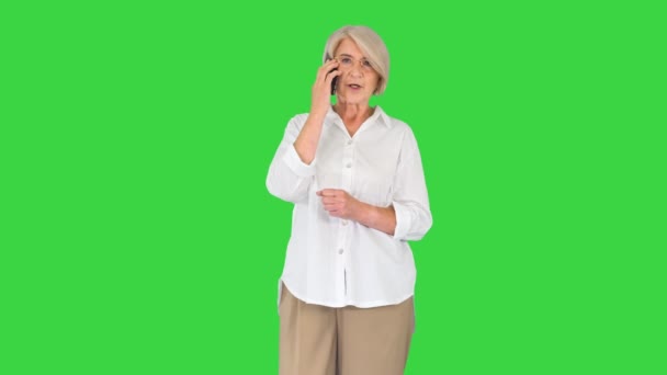 Mujer mayor feliz con teléfono inteligente haciendo una llamada en una pantalla verde, Chroma Key. — Vídeos de Stock