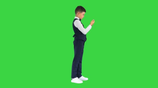 Niño en chaleco viendo algo en su teléfono y redondeando sus ojos en shock en una pantalla verde, Chroma Key. — Vídeo de stock