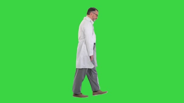 초록색 화면 위를 걷고 있는 슬픈 남자 의사 크로마 키. — 비디오