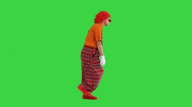 Üzgün, mutsuz palyaço Yeşil Ekran 'da komik bir şekilde yürüyor, Chroma Key.