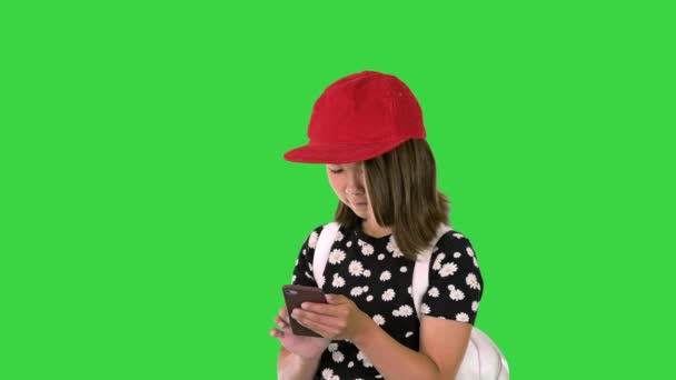 Jeune fille portant un sac à dos et utilisant un smartphone sur un écran vert, Chroma Key. — Video