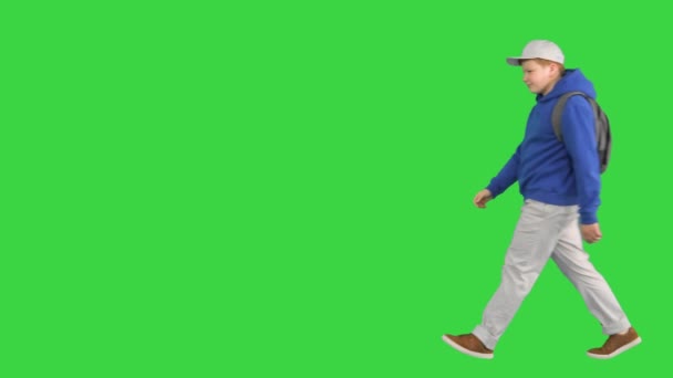 Menino da escola adolescente andando e fazendo um gesto de olá para a câmera em uma tela verde, Chroma Key. — Vídeo de Stock