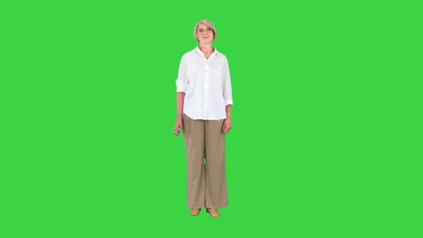 Donna anziana in camicia bianca in piedi senza fare nulla su uno schermo verde, Chroma Key. — Video Stock