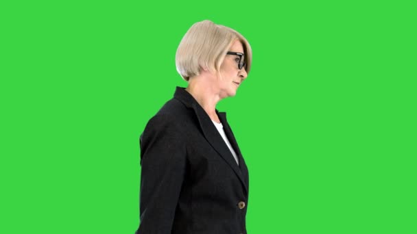 緑の画面、クロマキーの上を歩く眼鏡をかけてシニアビジネス女性. — ストック動画
