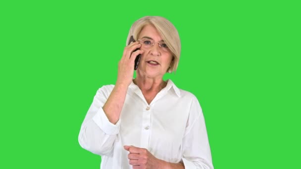 Seniorin mit Smartphone telefoniert auf grünem Bildschirm, Chroma Key. — Stockvideo