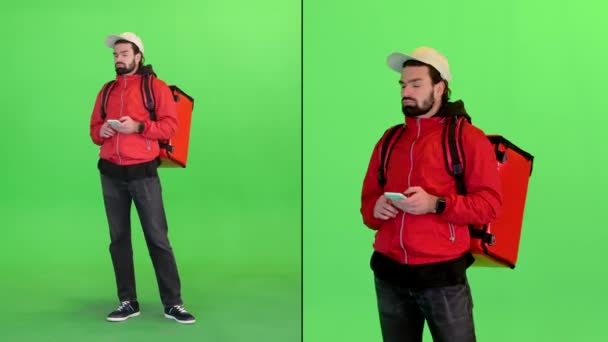 Entrega homem com mochila se perdeu e olhando para seu telefone em uma tela verde, Chroma Key. — Vídeo de Stock