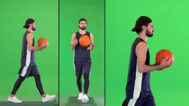 Aantrekkelijke vrolijke jonge fit basketbalspeler loopt met een bal in zijn handen op een groen scherm, Chroma Key. — Stockvideo