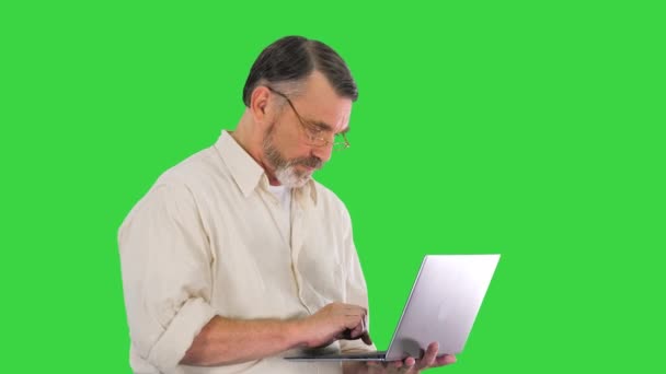 Dojrzały mężczyzna w okularach szczęśliwy, aby zakończyć pracę na laptopie na czas na zielonym ekranie, Chroma Key. — Wideo stockowe