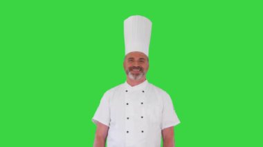 Bir erkek aşçı, yeşil ekran, Chroma Key 'de kameraya gülümsüyor..