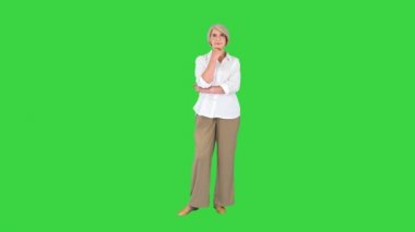 Gözlüklü kadın düşünüyor ve yeşil ekranı işaret ediyor, Chroma Key..