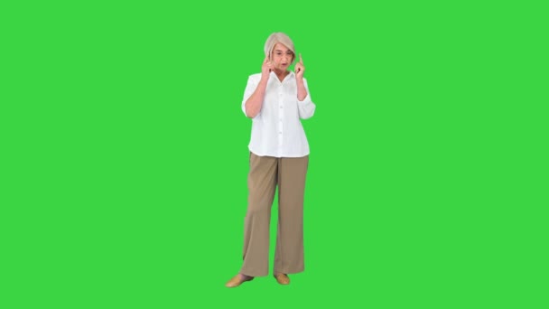 Encantadora mujer mayor hablando con alguien en una pantalla verde, Chroma Key. — Vídeos de Stock