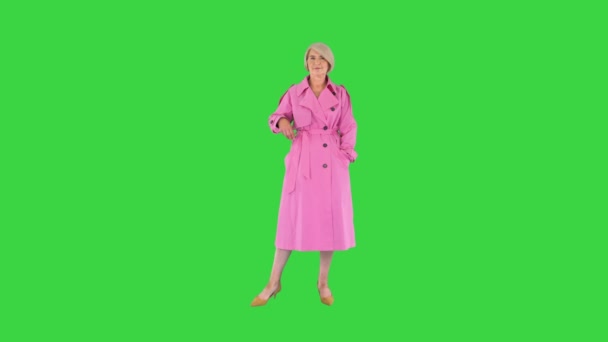 Hermosa señora mayor con estilo en gabardina posando a la cámara en una pantalla verde, Chroma Key. — Vídeos de Stock