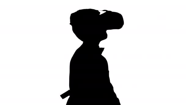 Silhouette Excited boy in formal wear playing the sword game in virtual reality goggles. — Stock Video