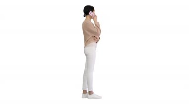 Telefonda konuşan ve beyaz arka planda el kol hareketi yapan duygusal gülümseyen genç bir kadın..