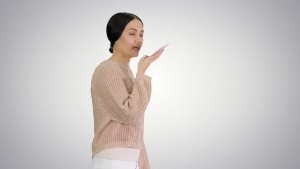 Genç bir kadın telefonda konuşuyor, gradyan arka planda yürürken yüzüne karşı tutuyor.. — Stok video