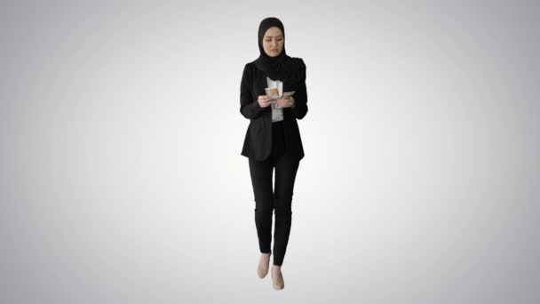 Jolie femme en hijab marchant et comptant l'argent sur fond de gradient. — Video