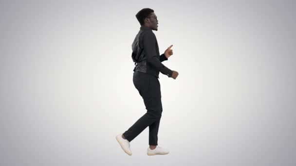 Afrikansk amerikansk forretningsmand i briller og binde dans med hænderne, mens han går på gradient baggrund. – Stock-video