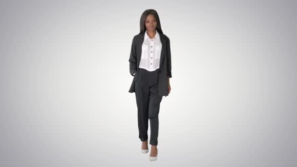 Femme d'affaires afro-américaine occasionnelle marchant sur fond de gradient. — Video