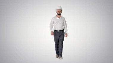 Resmi giyim ve beyaz şapkalı bir işadamı gradyan arka planda yürüyor.