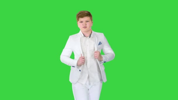 Jonge tiener jongen in een business suit staat voor de spiegel op een groen scherm, Chroma Key. — Stockvideo