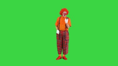 Akıllı telefonlu bir palyaço yeşil ekranda arama yapıyor, Chroma Key..