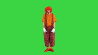 Mutsuz palyaço yeşil ekranda dikiliyor ve gergin, Chroma Key.