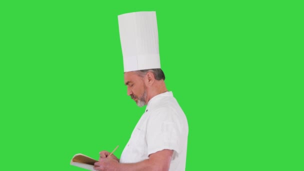 Cocinero masculino haciendo notas en una pantalla verde, Chroma Key. — Vídeo de stock