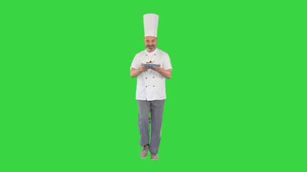 Heureux chef mature marchant avec désert dans les mains sur un écran vert, Chroma Key. — Video