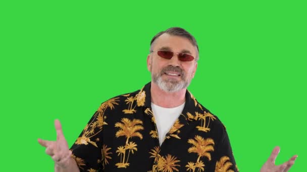 Velho homem sênior legal em casual falando com a câmera enquanto caminha em uma tela verde, Chroma Key. — Vídeo de Stock