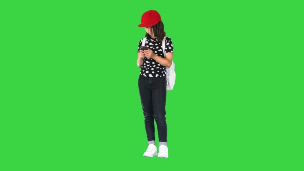 Casual schoolmeisje check haar e-mail met een mobiele telefoon op een groen scherm, Chroma Key. — Stockvideo