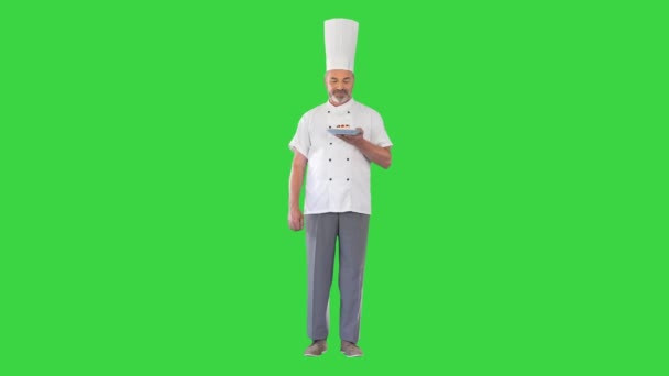 Reifer Koch, Koch oder Bäcker hält Teller mit Dessert und macht Geste der Zustimmung auf einem Green Screen, Chroma Key. — Stockvideo