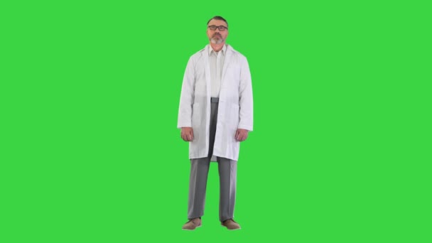 Érett orvos összecsukott karokkal áll a zöld képernyőn, Chroma Key. — Stock videók