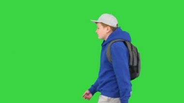 Sırt çantalı öğrenci yeşil ekranda yürüyor, Chroma Key.