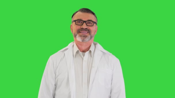 Starší lékař stojící a usmívající se na kameru na zelené obrazovce, Chroma Key. — Stock video