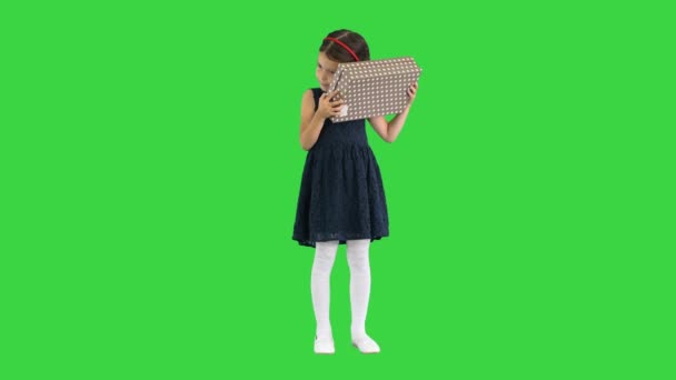 Glückliches Mädchen im schwarzen Kleid schüttelt sich und öffnet Geschenkbox lächelnd in die Kamera auf einem Green Screen, Chroma Key. — Stockvideo