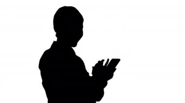 Siluet Gülümseyen İş kadını Telefonundaki fotoğraflara bakıyor.