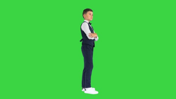 Menino em um laço gravata de pé com braços cruzados e olhando para cima pensando em uma tela verde, Chroma Key. — Vídeo de Stock
