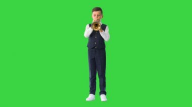 Papyonlu küçük bir çocuk yeşil ekranda trompet çalıyor, Chroma Key..