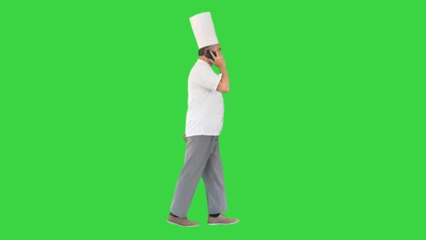 Chef falando no telefone enquanto caminha em uma tela verde, Chroma Key. — Vídeo de Stock