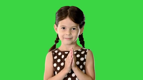 Dziewczynka w sukience w kropki klaszczącej w dłonie patrząc w kamerę na zielonym ekranie, Chroma Key. — Wideo stockowe