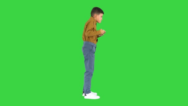 Petit garçon émotionnel jouant à des jeux vidéo avec joystick dans ses mains sur un écran vert, Chroma Key. — Video
