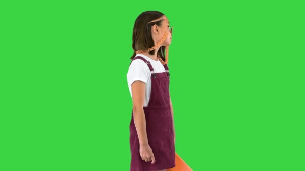 Молода випадкова дівчинка в тіні тримає скейтборд на зеленому екрані, Chroma Key. — стокове відео