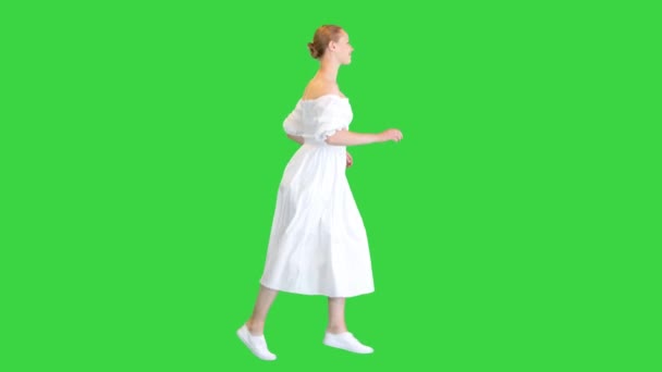 पांढरा ड्रेसमध्ये तरुण स्त्री ग्रीन स्क्रीनवर चालत आहे, क्रोमा की . — स्टॉक व्हिडिओ