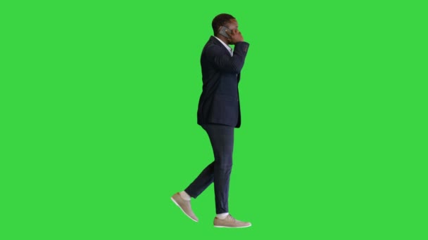 Homem afro-americano feliz andando e falando ao telefone em uma tela verde, Chroma Key. — Vídeo de Stock