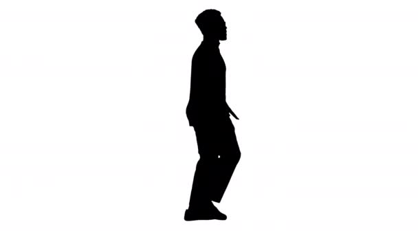 Silhouette Fiatal afro-amerikai férfi szürke ruhában és szemüvegben barázdálás séta közben. — Stock videók