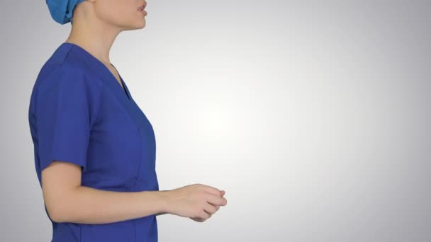 Médica em uniforme azul falando sobre cuidados médicos em fundo gradiente. — Vídeo de Stock