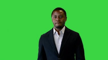 Yeşil Ekran 'da yürüyen takım elbiseli, kendine güvenen siyah iş adamı, Chroma Key.